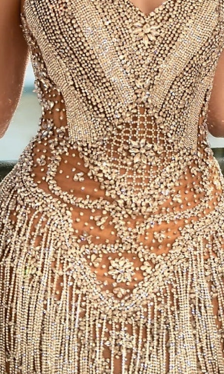 Close-up of the Portia and Scarlett PS25408C short homecoming dress, showcasing its strapless design with intricate beadwork and sparkling rhinestones in geometric and floral patterns over sheer nude fabric.